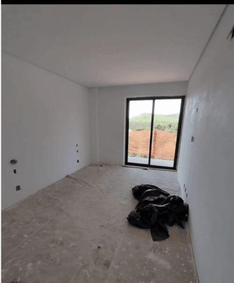 Quarto em fase de acabamento com porta de vidro para área externa