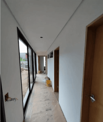 Corredor residencial com grandes esquadrias de vidro e portas de madeira