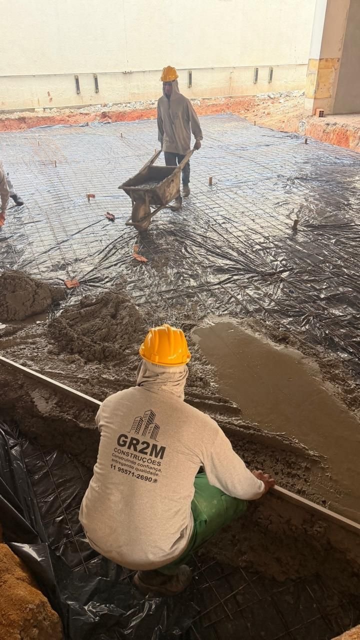 Profissionais com uniforme GR2M trabalhando na concretagem de piso