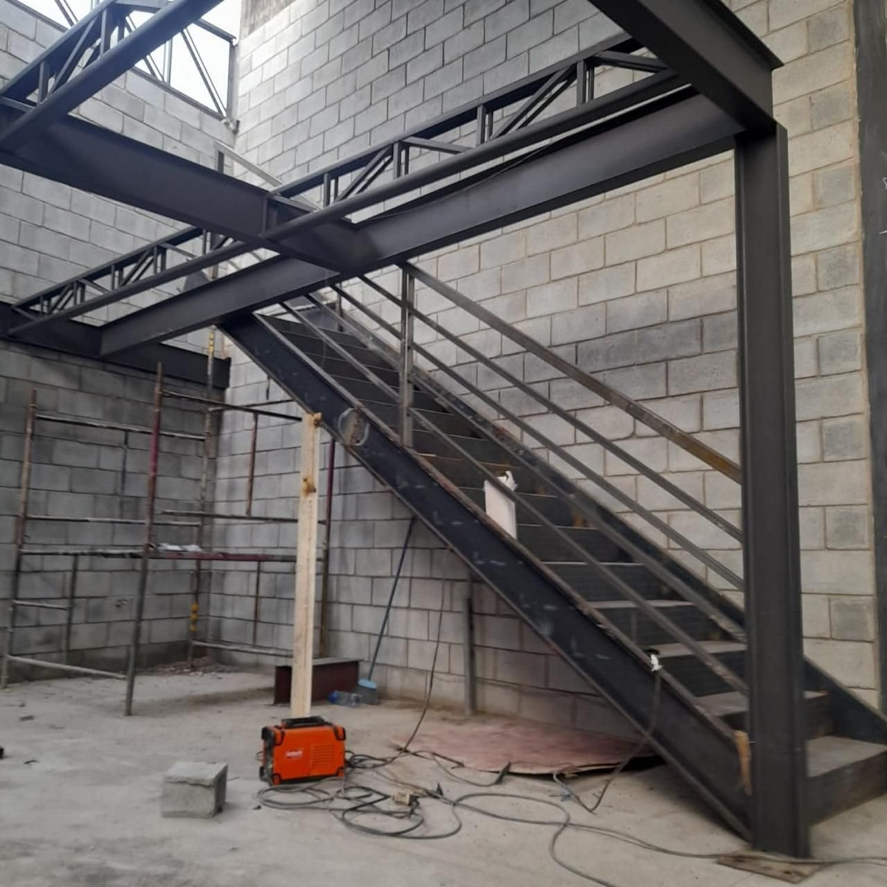 Escada e mezanino em estrutura metálica em ambiente interno de obra