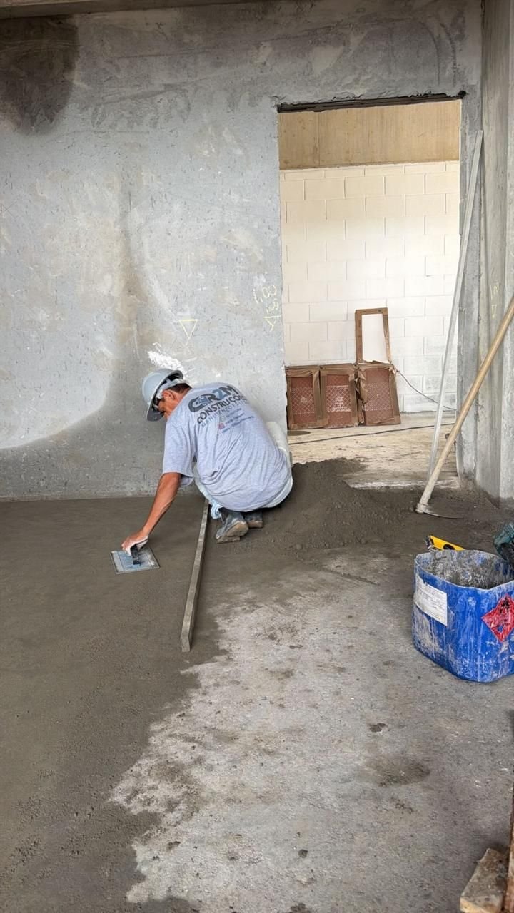 Profissional com uniforme GR2M nivelando contrapiso