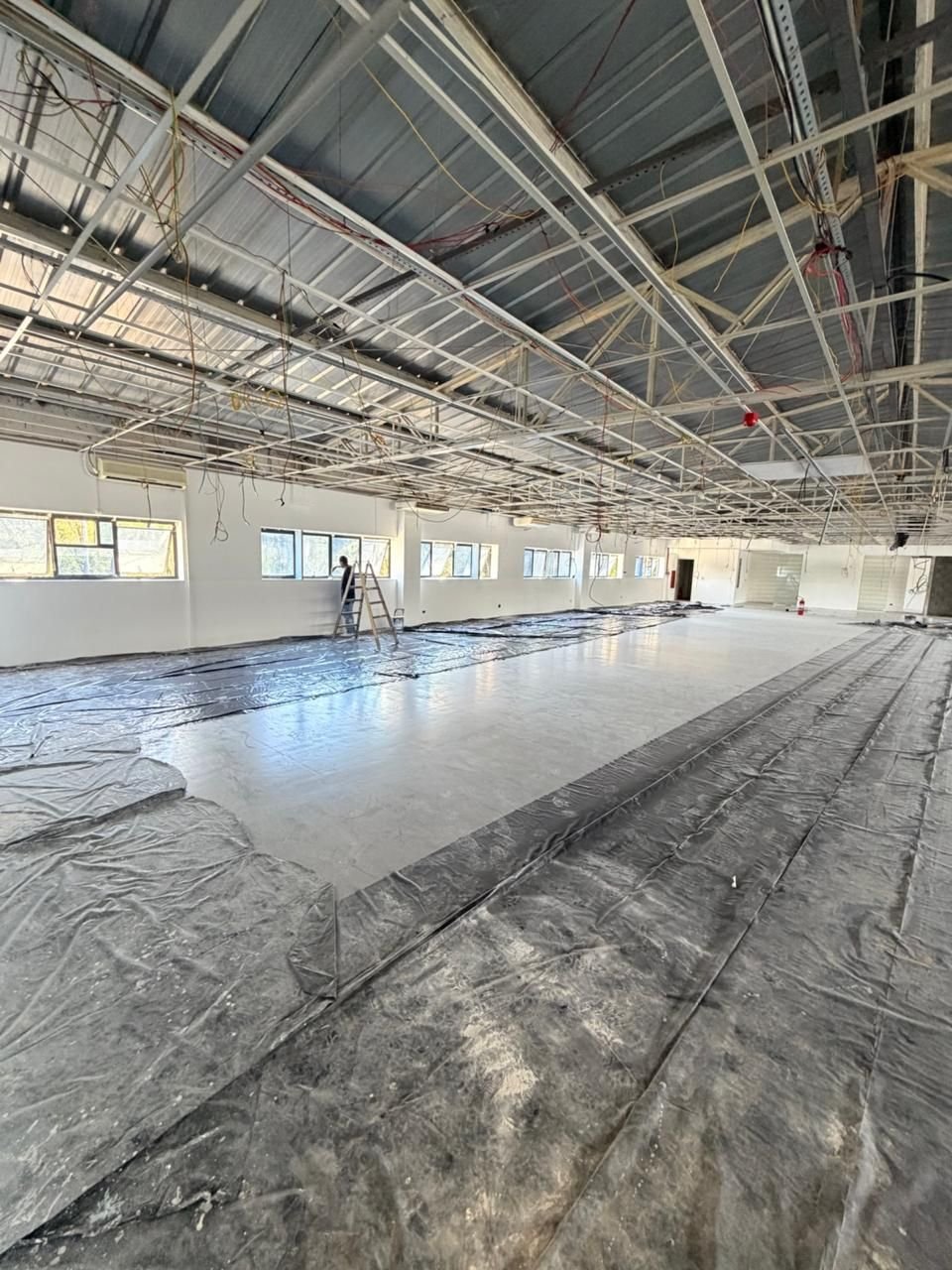 Amplo espaço comercial em obra, com estrutura de forro e piso protegido