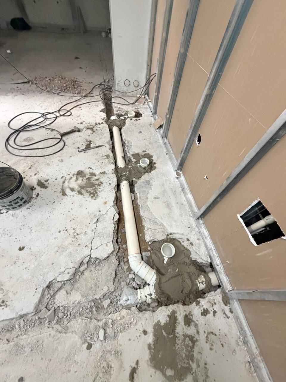 Tubulação hidráulica embutida no piso ao lado de parede em drywall
