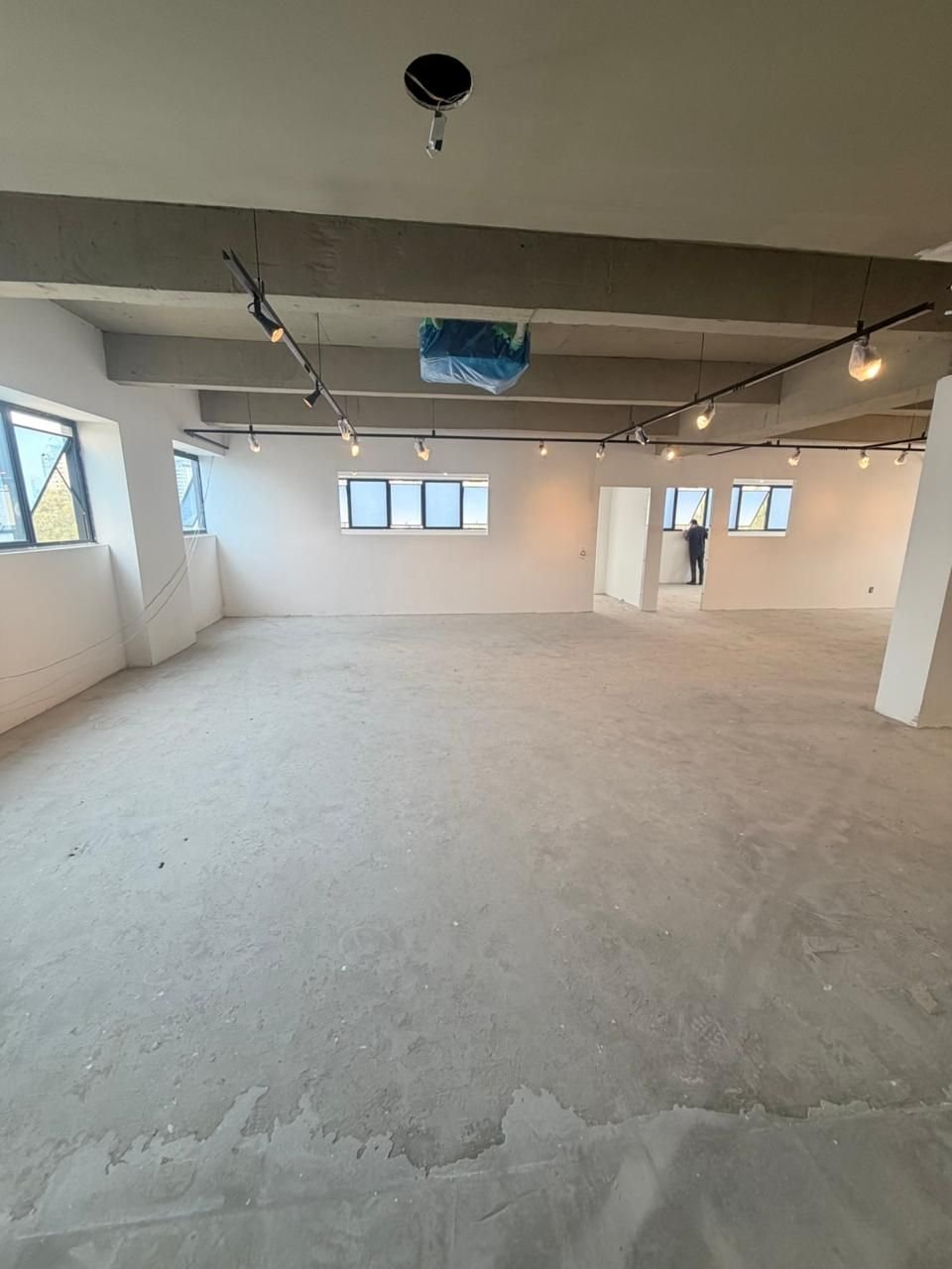 Sala comercial com paredes pintadas e trilhos de iluminação